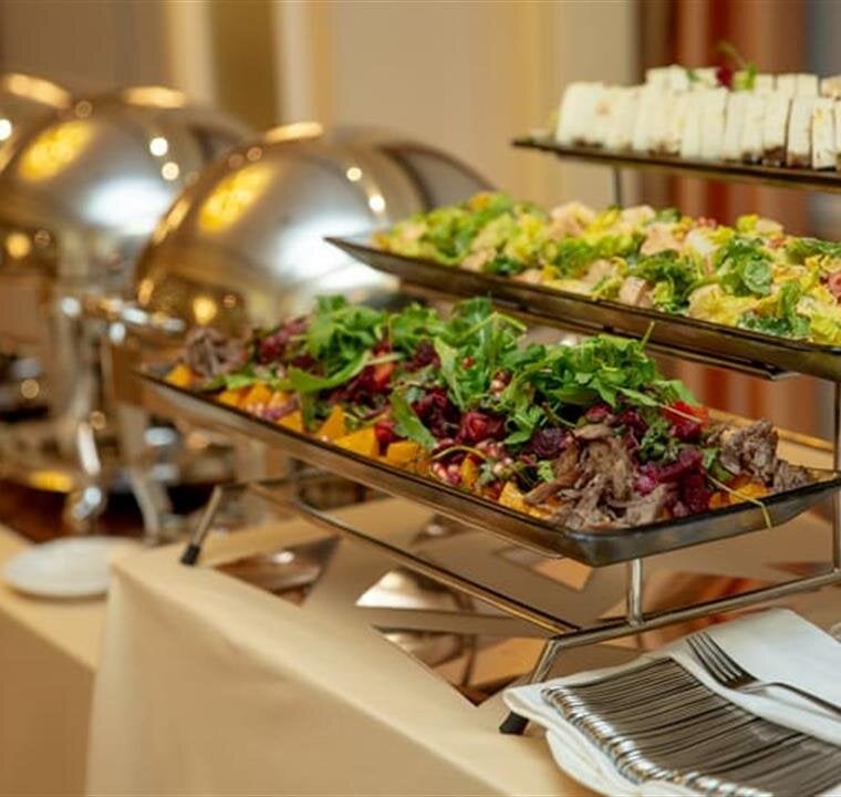 A lavish buffet table features colorful salads and gourmet entrees, highlighting culinary artistry.