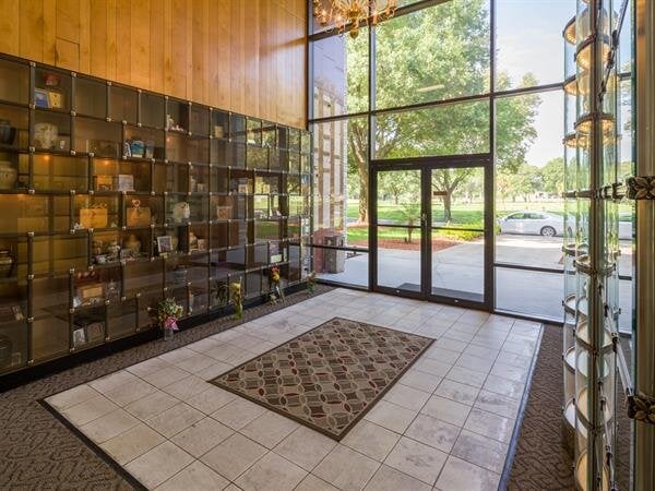 The memorial hall features bright interiors, display units with urns, and outdoor views.