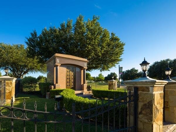 Lush green foliage surrounds a beautifully crafted garden entrance on a sunny afternoon.