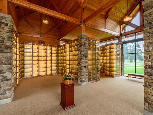 Contemporary chapel interior with stone accents and memorial niches, offering a serene vibe.