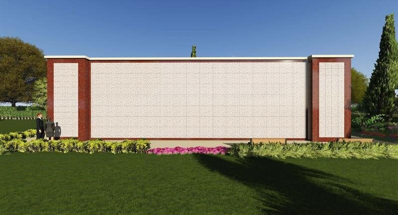 Golden sunlight filters through trees in an autumn park, highlighting vibrant leaves on the ground.