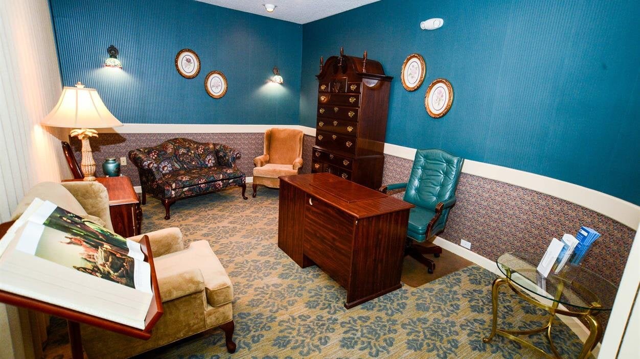 Spacious office with furniture, blue walls, and natural light from the windows.