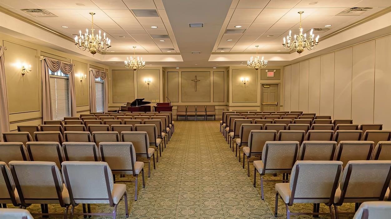 Chairs are arranged in rows in a large room for a gathering or event with no people present.