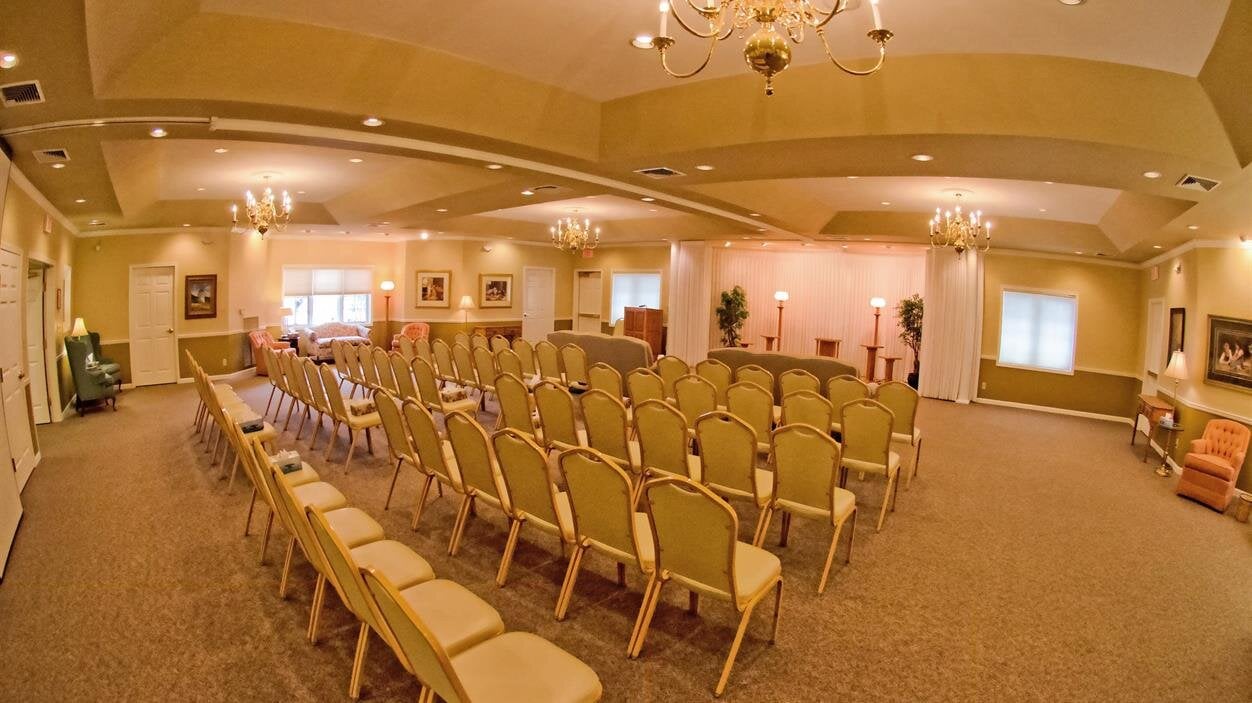 Chairs are arranged in rows in a large hall for a planned gathering in the afternoon.