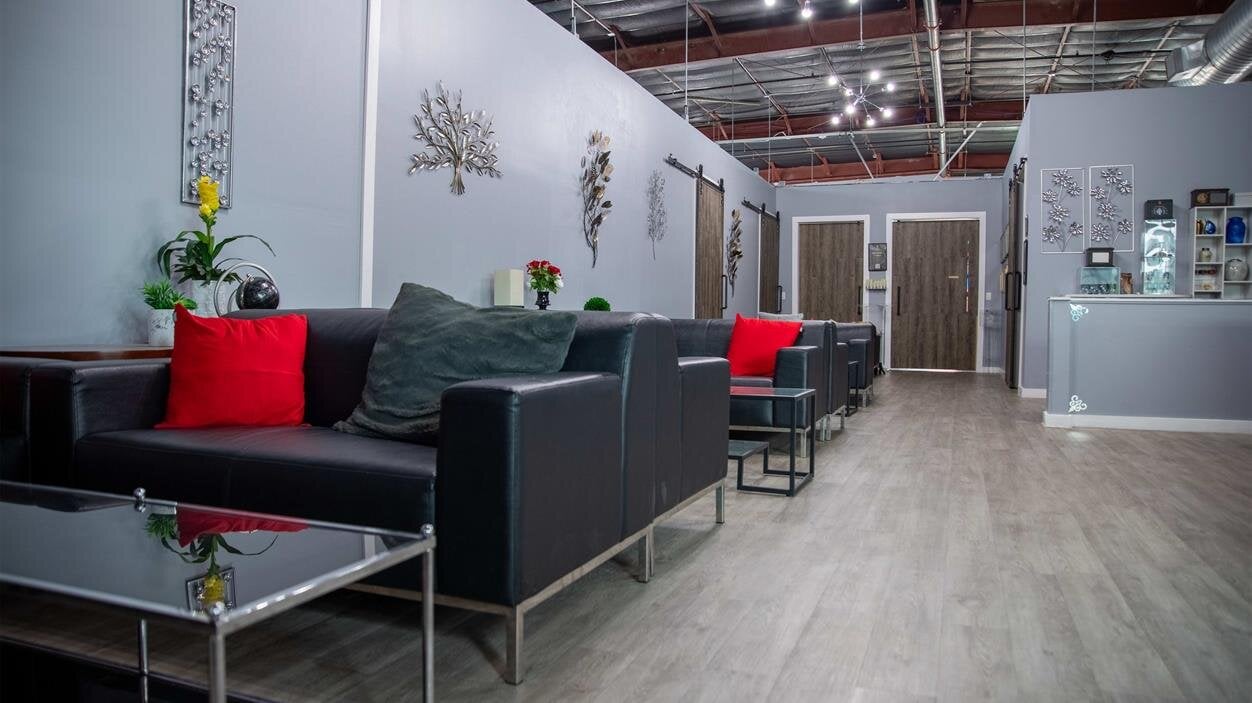 A room with black couches and chairs