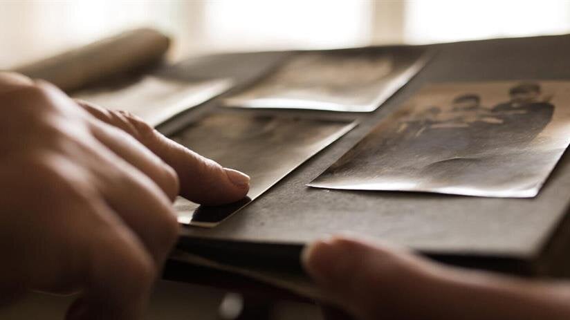 A person's hands looking at photos