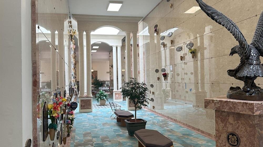 Visitors walk through a beautifully decorated corridor filled with sculptures and artistic details.