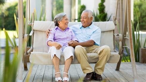 A man and woman sitting on a swing