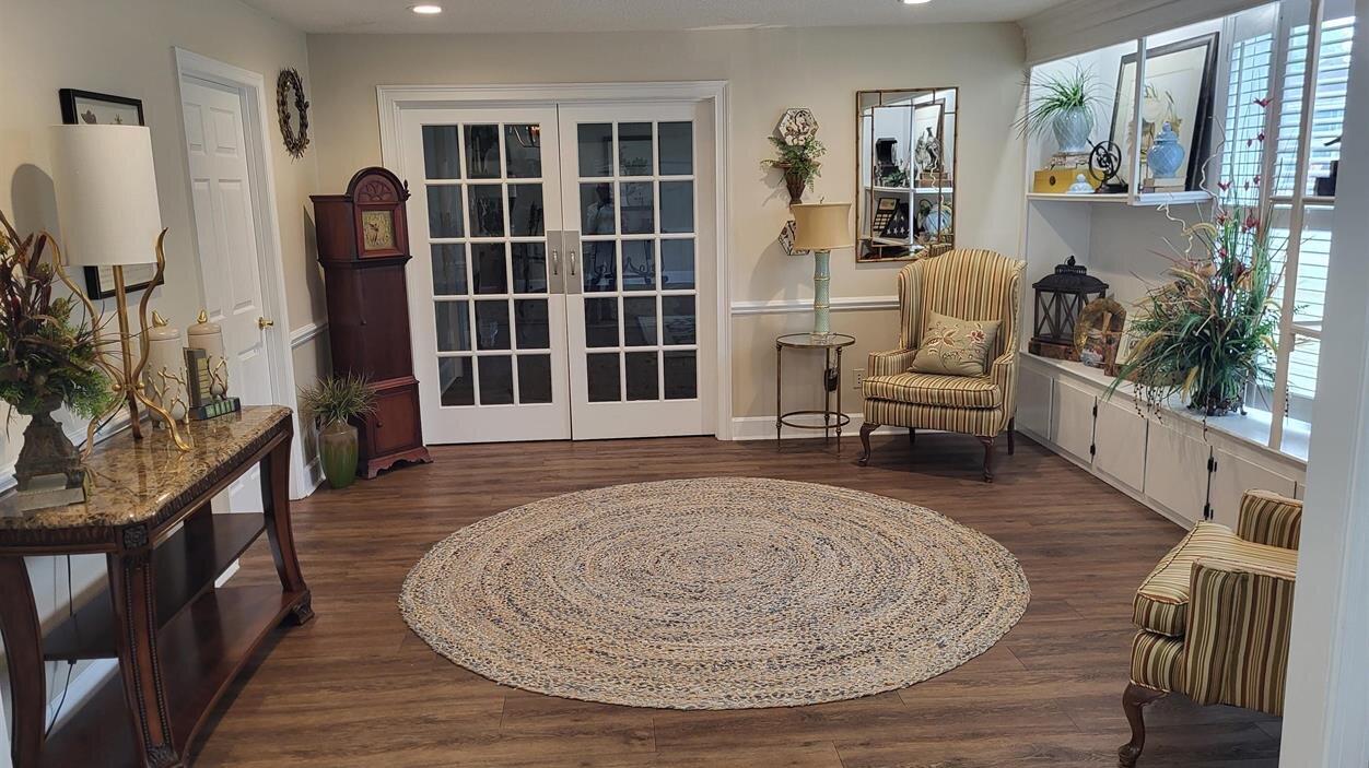 A room with a round rug and a couch