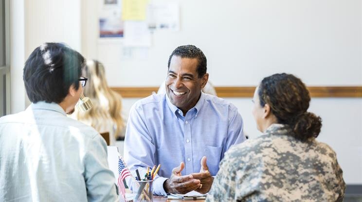 A man in a blue shirt talking to a group of people