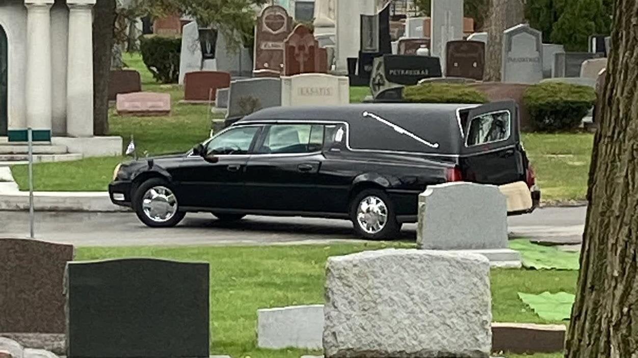 A hearse parked in a cemetery