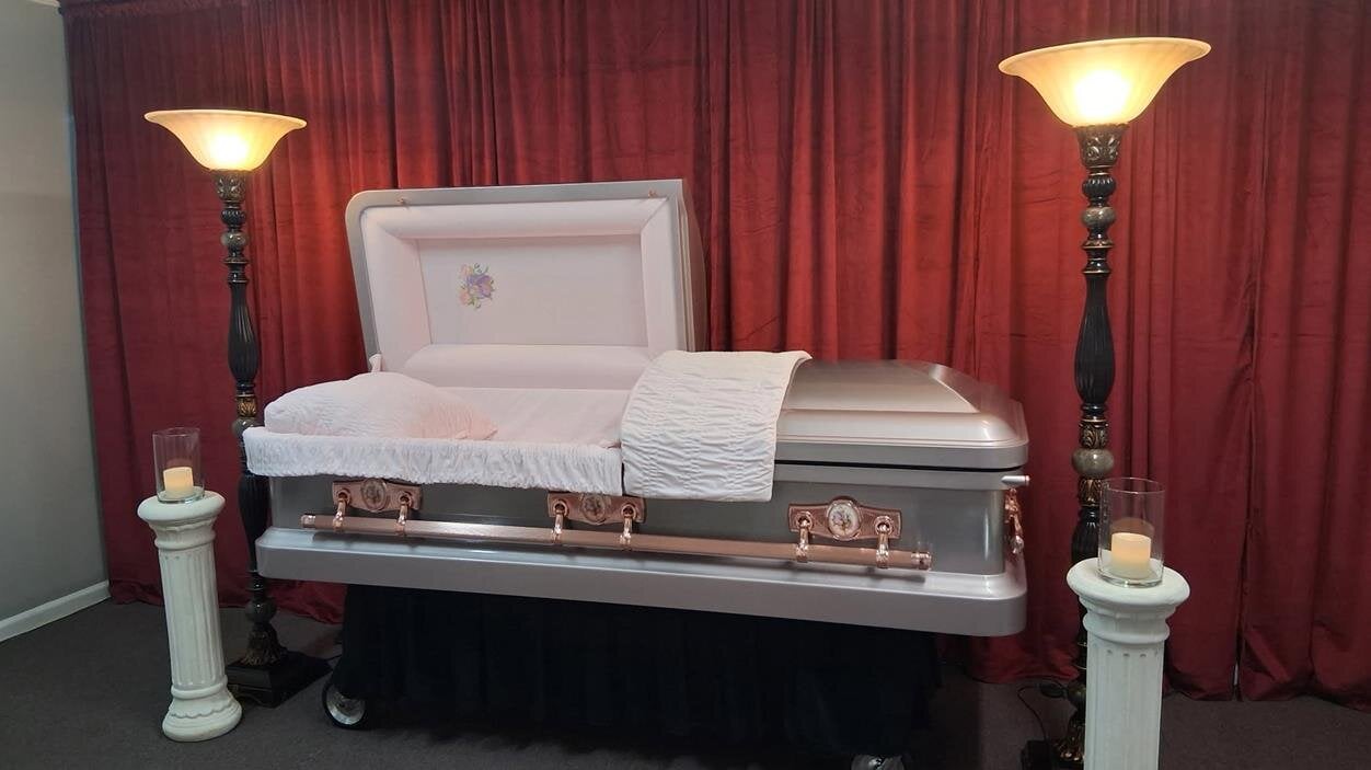 A coffin with two lamps next to it