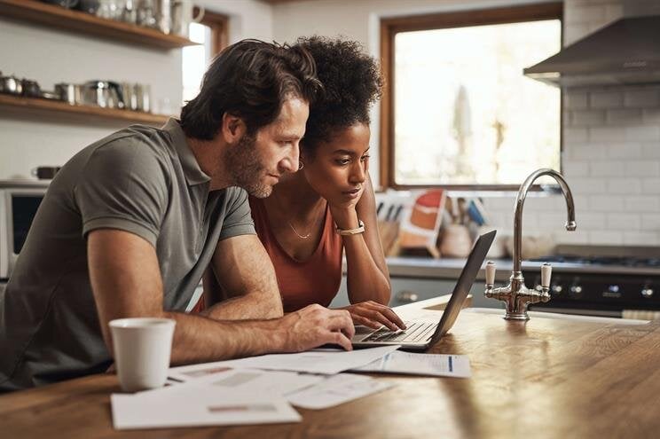 A man and woman looking at a laptop