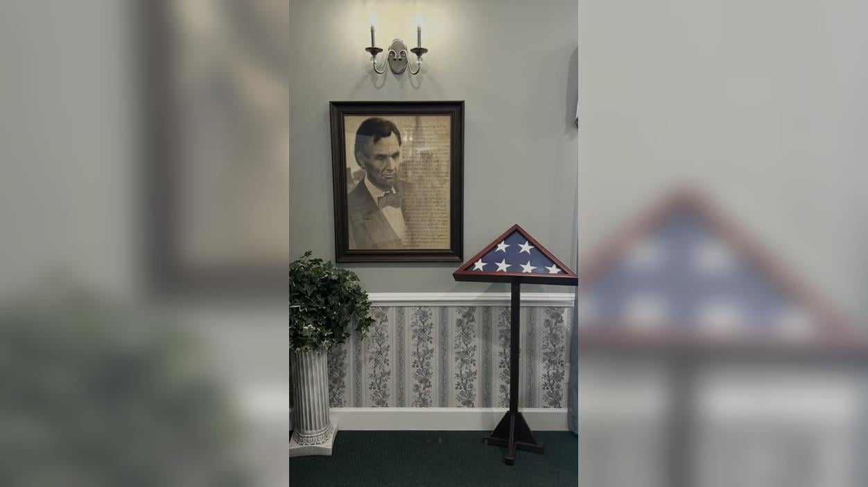 A framed picture of a man in a bow tie and a flag