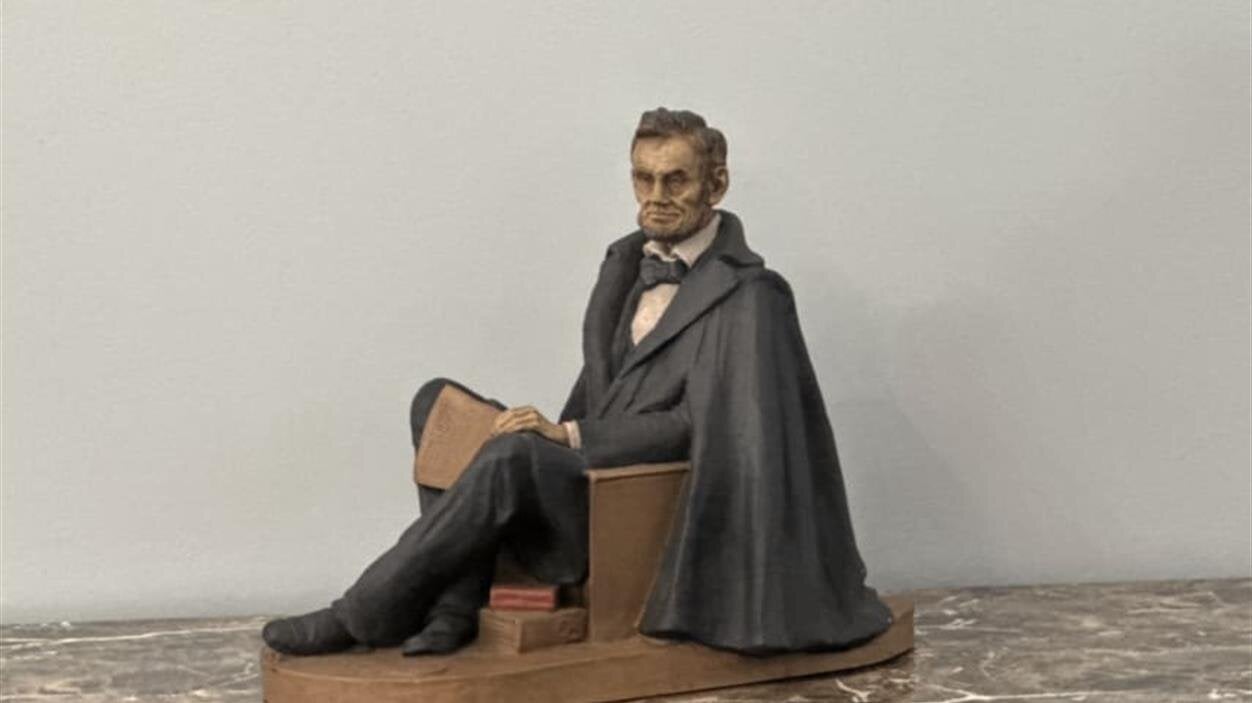 A statue of a man sitting on a chair