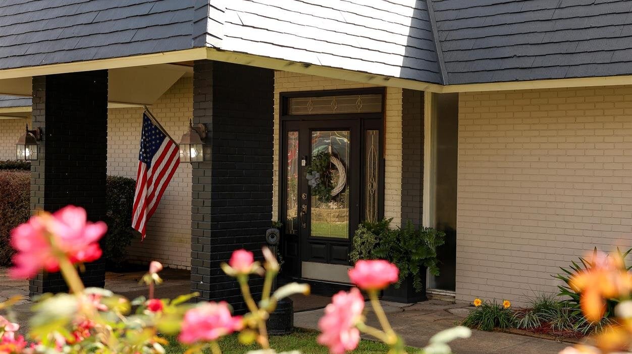 A house with a flag and flowers