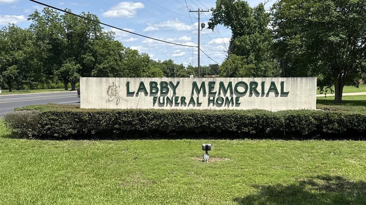 A sign in front of a lawn