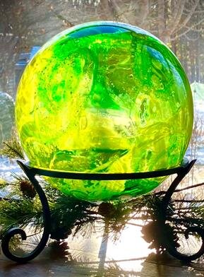 A green and yellow sphere on a stand