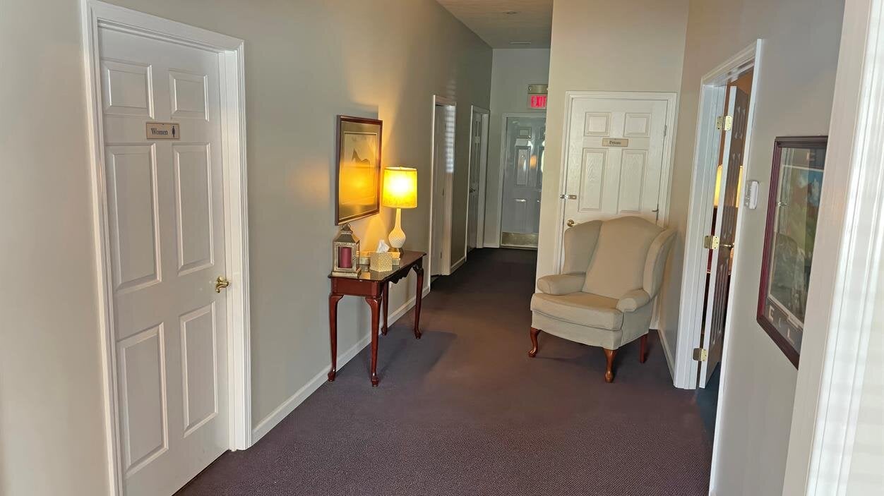 A hallway with a chair and a table