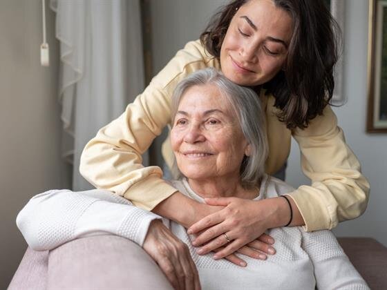 A woman hugging an older woman