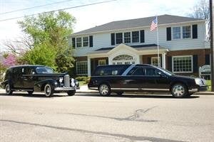 A 1937 LaSalle Carved Side Coach , and a 2005 Glass State Coach parked in front of Pray Funeral Home.
