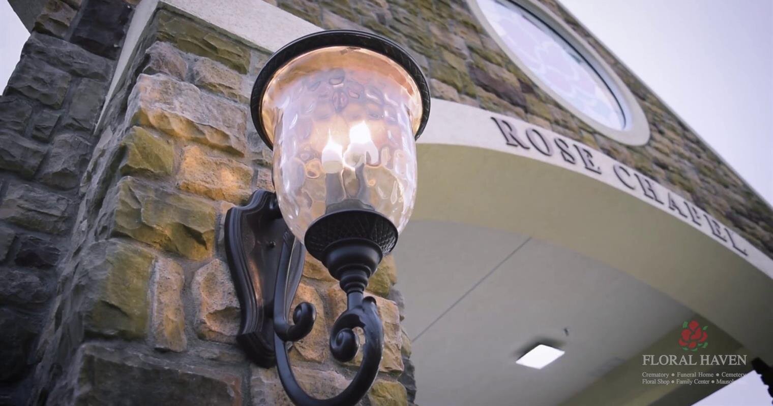 The lamp illuminates the entrance of Rose Chapel, enhancing the serene atmosphere at dusk.