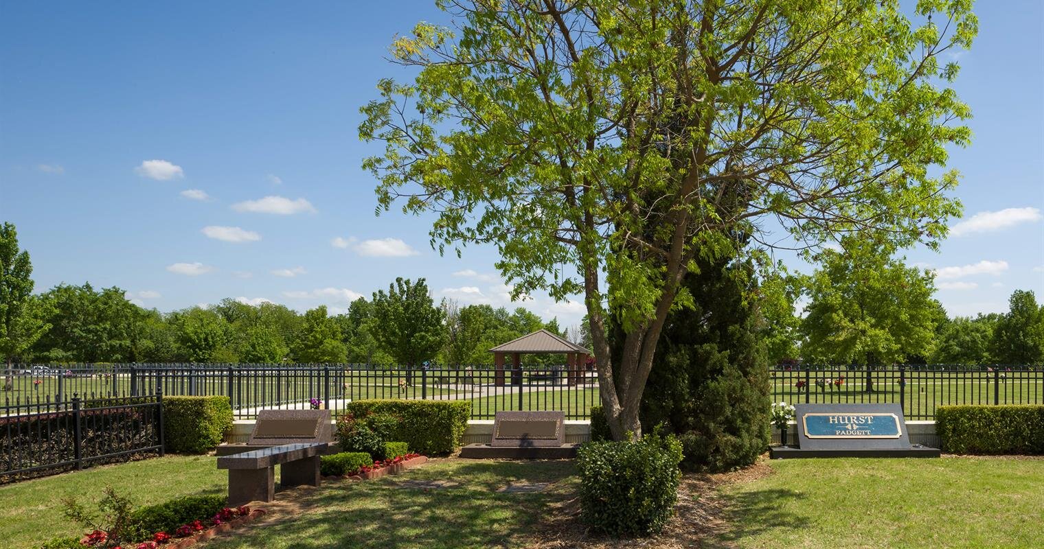 A peaceful park setting with a gazebo and vibrant greenery on a sunny afternoon.