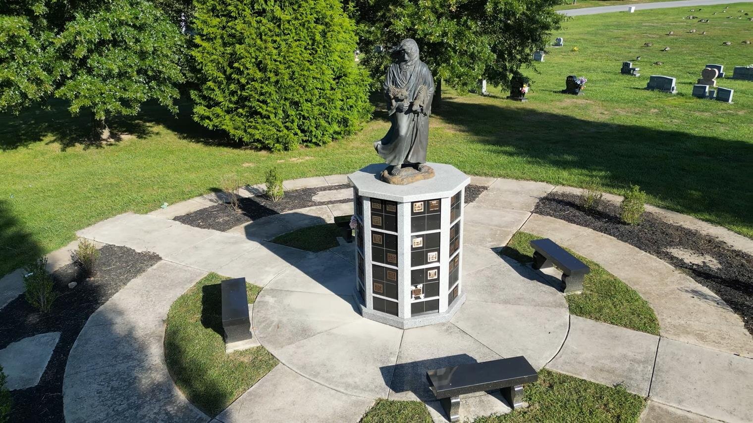 peacefully nestled in open green space, this serene garden features a beautiful statue of the Good Shepherd surrounded by a