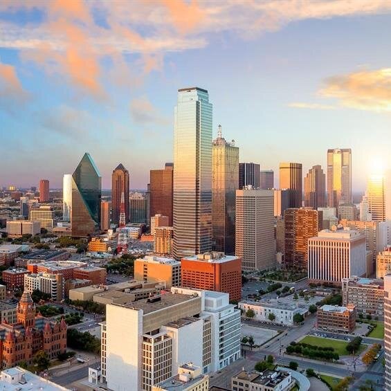 Dallas skyline glows with vibrant sunset colors, blending modern and historic architecture.