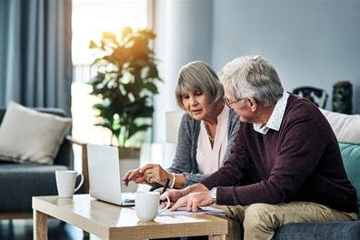 Couple shares ideas and insights while working together on a laptop in their home.