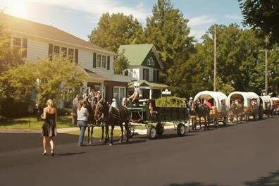 A horse drawn carriage with people walking