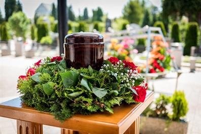 People prepare a table with herbs and flowers for a weekend event in a garden setting.