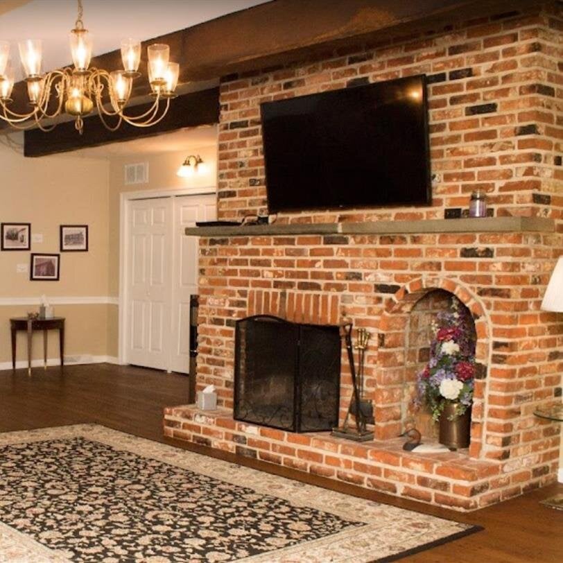 A living room with a fireplace and a rug