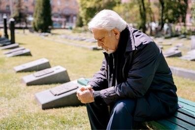 A man sitting on a bench in a cemetery