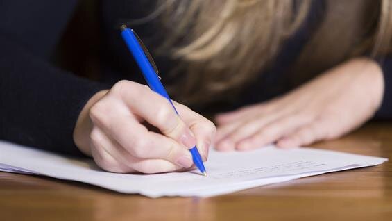 A person writing on a piece of paper