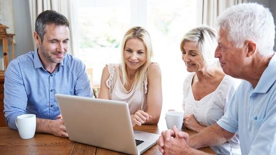 A group of people looking at a laptop