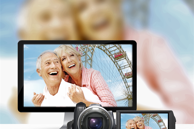 A camera and a monitor with a couple of people in the background