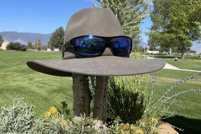 A hat and sunglasses on a planter