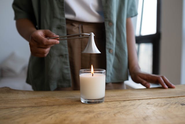 Person gently extinguishing a memorial candle during a remembrance ceremony in Albany, NY