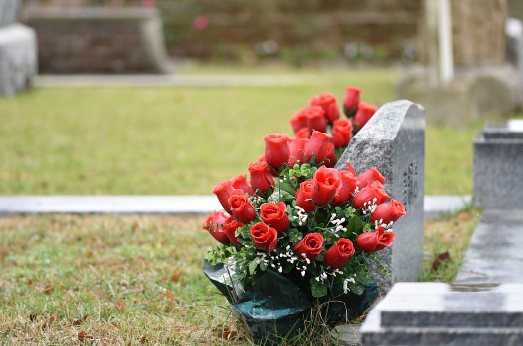 Red roses placed at a gravesite for respectful funeral and cremation care in Mount Holly, NJ