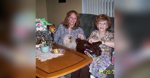 Two friends sit together at a table, enjoying snacks and chatting in a warm atmosphere.