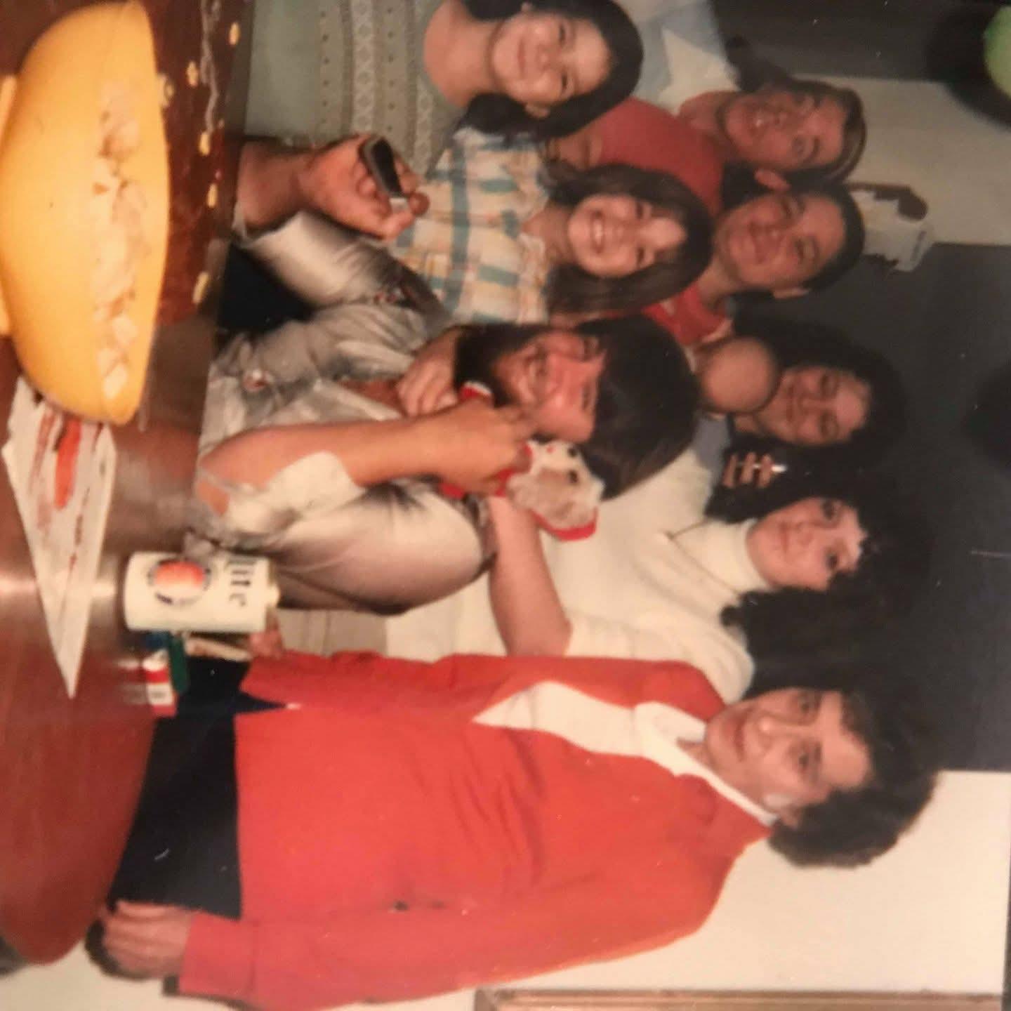 A group of ten people enjoy a cheerful evening together, sharing laughter and drinks.