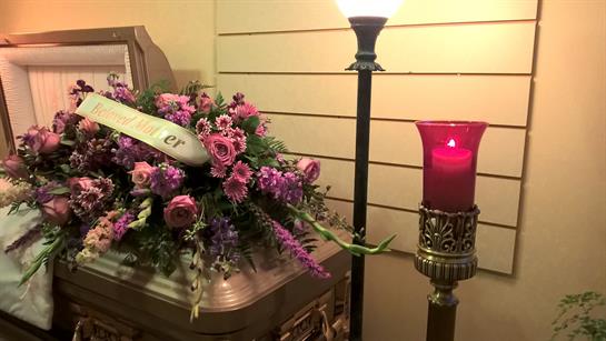 A casket with flowers and a candle
