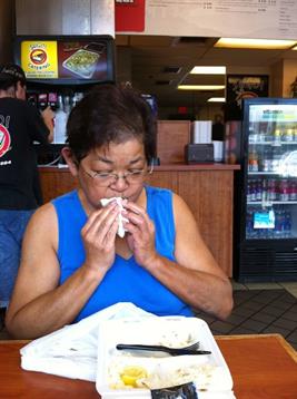 A woman sitting at a table with a napkin in her hand