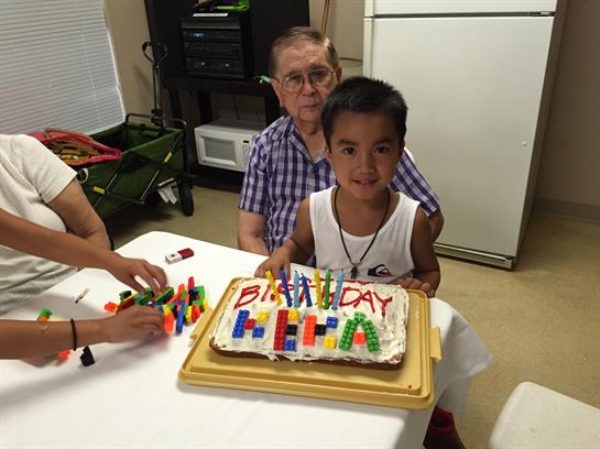 A boy sitting at a table with a birthday cake