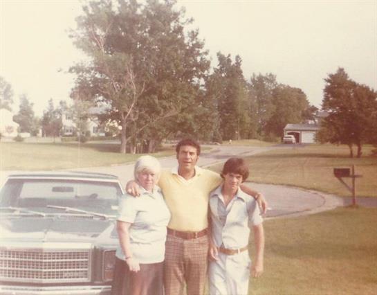 A group of people standing in front of a car