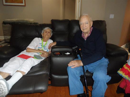 An elderly couple sitting on a couch