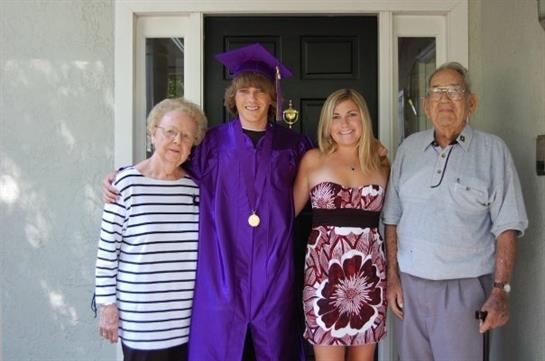 Family gathers to celebrate graduation day with smiles and proud moments in front of the house.