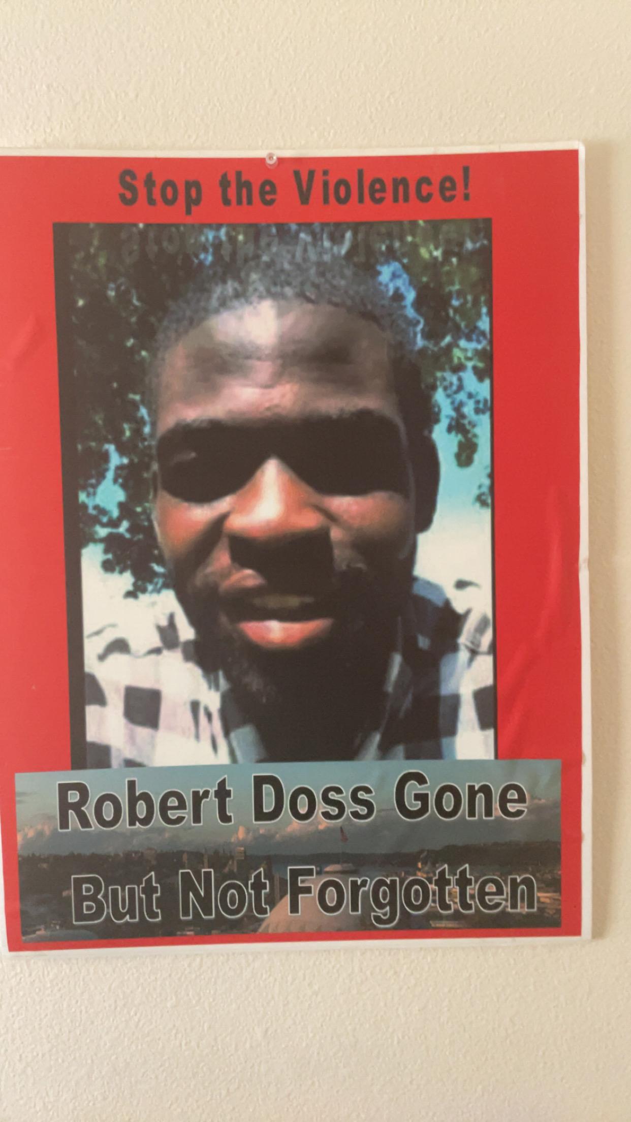 A community poster highlights the message against violence while remembering Robert Doss.