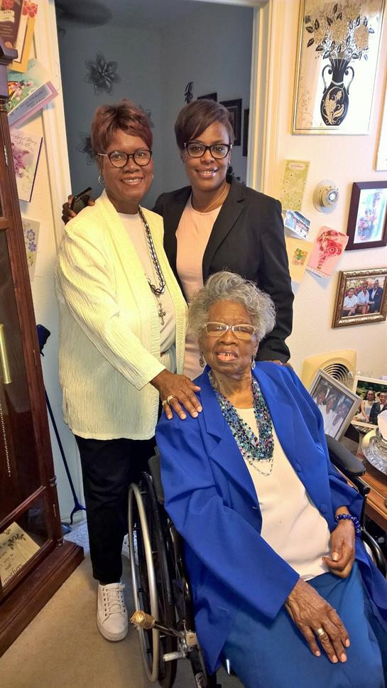 Family members smile and pose together, showcasing their bond in a warm living room.
